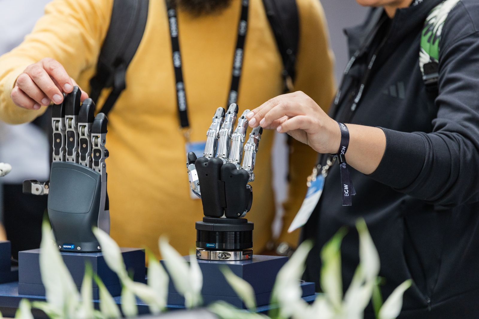 Visitors trying TACTILIA robotic hands on display at an industry event
